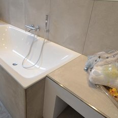 Ein modernes Badezimmer mit einer eleganten Badewanne und einem stilvollen Waschbecken, das eine entspannende Atmosphäre schafft.
