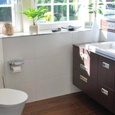 Ein modernes Badezimmer mit einem eleganten Waschbecken, Holzregalen und Pflanzen, die eine frische Atmosphäre schaffen.