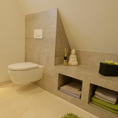 Ein modernes Badezimmer mit einer schwebenden Toilette, einem Buddha-Statuette und stilvollen Aufbewahrungskörben.