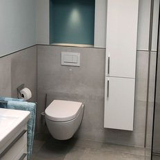 Das Badezimmer zeigt eine stilvolle Toilette und einen Handtuchhalter mit einem blauen Handtuch, das für einen Farbtupfer sorgt.