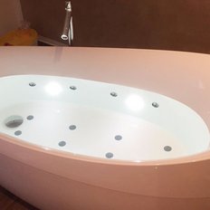 Eine elegante, freistehende Badewanne mit sanften Kurven und integrierter Beleuchtung, die eine entspannende Atmosphäre schafft.